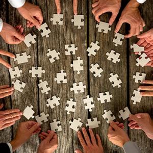 Búsqueda de sinergias - Diferentes manos haciendo un puzzle con piezas