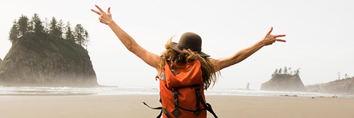 Préstamo Preconcedido - Mujer con mochila saltando en playa desierta Préstamo Preconcedido - Mujer con mochila saltando en playa desierta