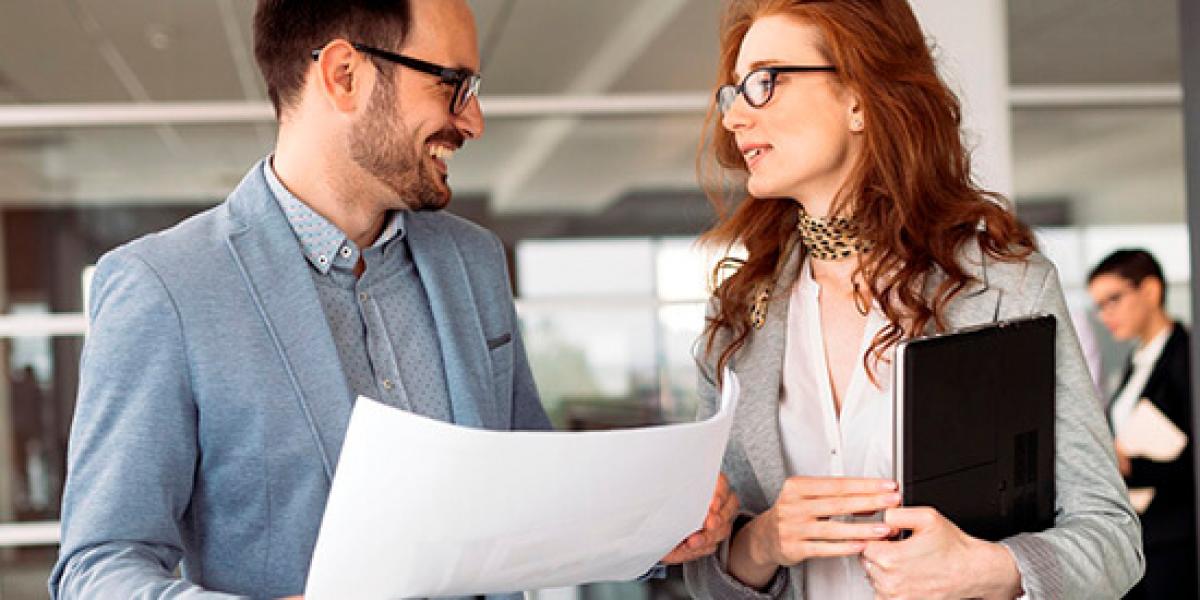 Promocion Servicio Comercio Exterior - Hombre y mujer con traje hablando en la oficina sobre comercio exterior con papeles en las manos